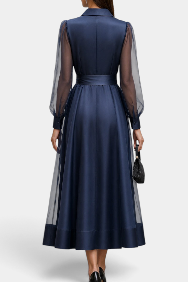 Back view of Mahaute Eirene midi dress in navy satin with sheer long sleeves, shirt collar, and a tied waist.