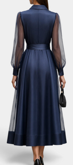 Back view of Mahaute Eirene midi dress in navy satin with sheer long sleeves, shirt collar, and a tied waist.