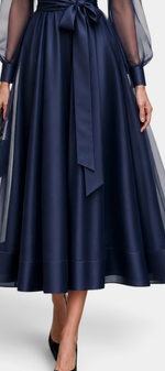 Mahaute Eirene midi dress in navy satin with sheer sleeves, a tied waist, and a flared skirt for formal events.