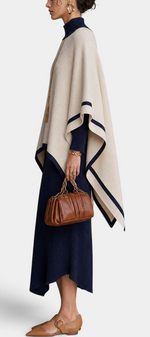 Mahaute ensemble featuring a navy ribbed turtleneck maxi dress and a cream poncho with navy contrast trim
