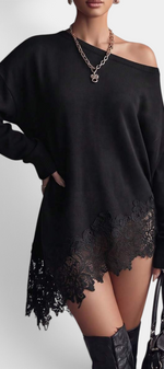 Mahaute Mishel black oversized knit sweater dress with an off-shoulder neckline and delicate floral lace hem detail.