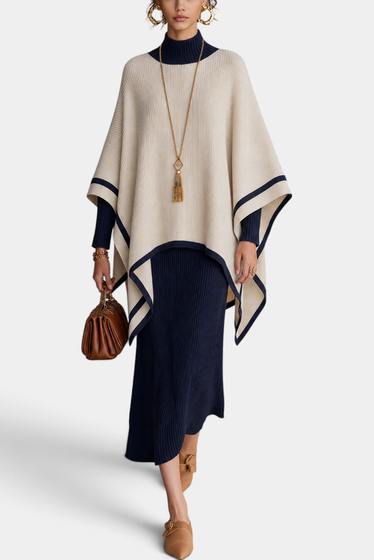 Mahaute ribbed knit long dress and contrasting poncho set in navy and cream worn by a model with gold accessories.