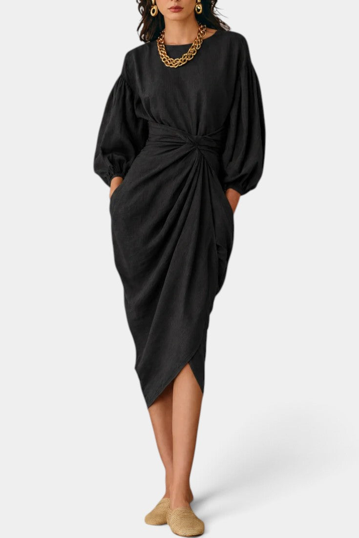 Robe mi-longue Mahaute Merjem avec taille nouée, manches ballon et tissu drapé, élégante et fluide, portée par un mannequin.