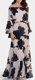 Robe longue fleurie Mahaute Lamija avec épaules dénudées, volants superposés et motif floral élégant.