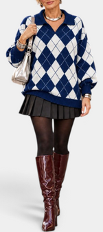 Mahaute Zafloria navy and white argyle knit polo sweater with puff sleeves worn with a black pleated skirt and boots.