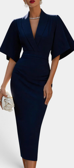 Mahaute Radoslava navy blue midi wrap dress with flared sleeves and a cinched waist, styled with a white clutch.
