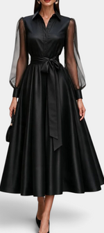 Mahaute Eirene midi shirt dress in black satin with sheer long sleeves, button-up bodice, and a tie-waist belt.