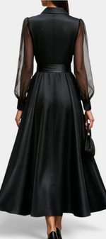 Back view of Mahaute Eirene midi dress in black satin with sheer long sleeves, shirt collar, and a tied waist.