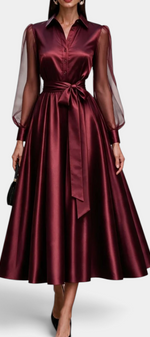 Mahaute Eirene midi dress in burgundy satin with a shirt collar, sheer sleeves, and a matching tie waist.
