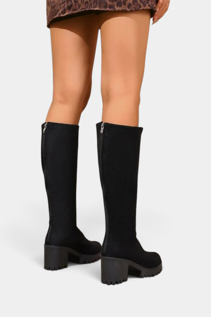 Mahaute Suny black knee-high boots with a chunky block heel and lug sole, viewed from the back.