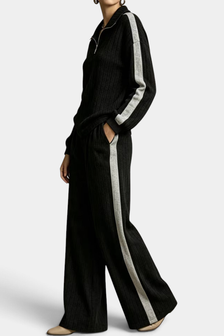 Mahaute black ribbed knit lounge set with zip-up sweater and wide-leg trousers featuring contrasting side stripes.