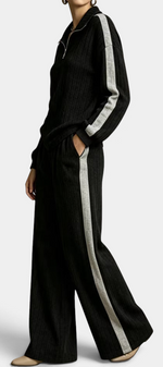Mahaute black ribbed knit lounge set with zip-up sweater and wide-leg trousers featuring contrasting side stripes.