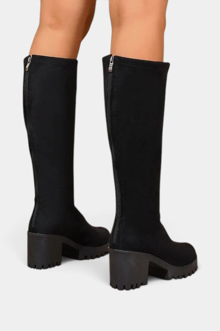 Mahaute Suny black high-leg boots with a chunky block heel and lug sole, featuring a back zipper closure.
