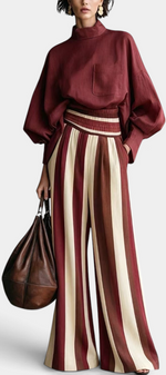 Mahaute Orlianne burgundy blouse with puff sleeves and high-waisted wide-leg striped trousers.