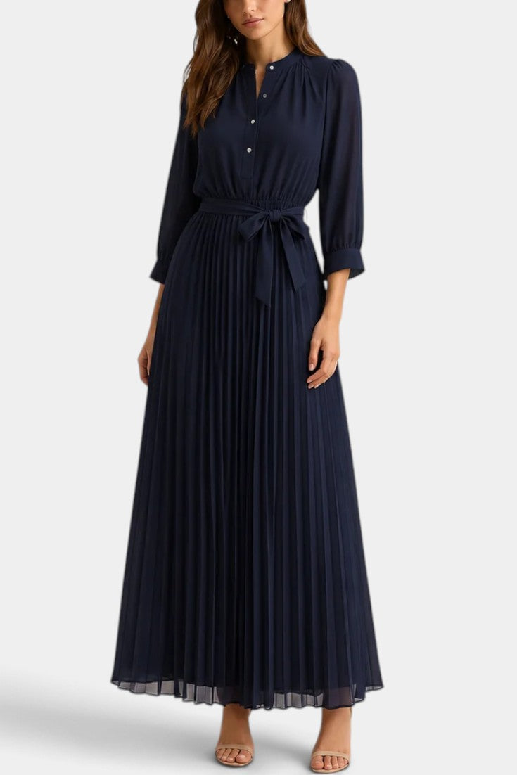 Robe longue en dentelle florale Mirelda de Mahaute, avec boutons et taille nouée, portée dans un style élégant.