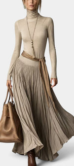 Robe longue Mahaute Zélidie à col roulé, jupe plissée et taille nouée, portée en style élégant et sophistiqué.