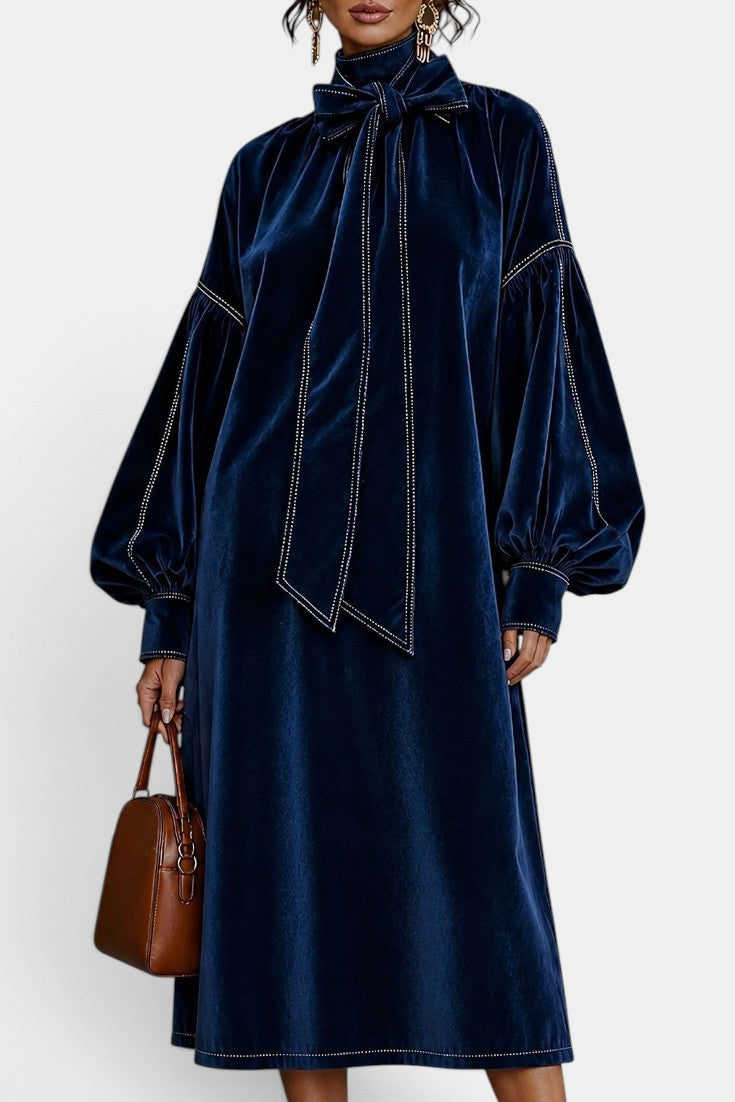 Robe mi-longue en velours Mahaute Théodeline avec col lavallière et manches bouffantes, portée sur mannequin.