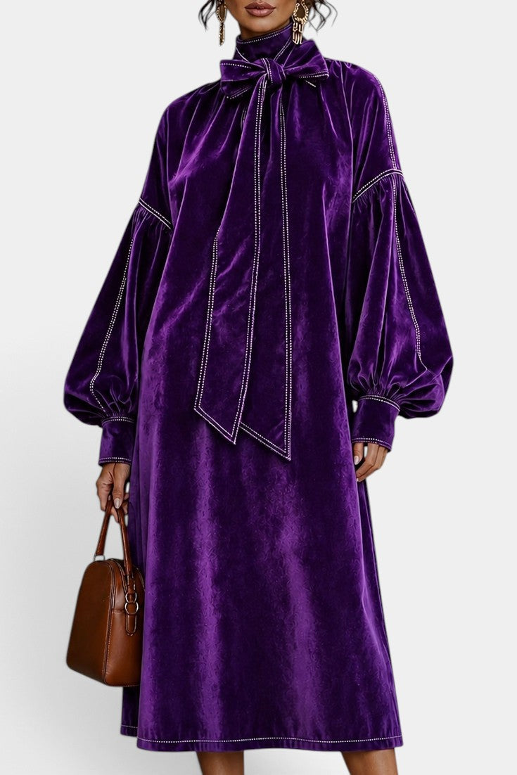 Robe mi-longue en velours Mahaute Théodeline avec col lavallière et manches bouffantes, portée sur un mannequin.