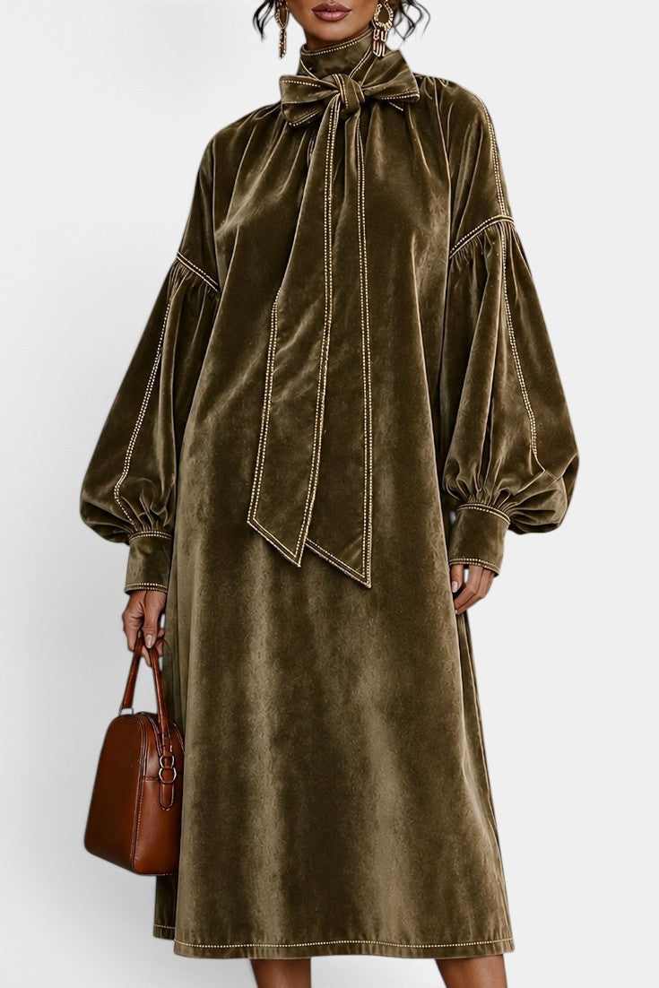 Robe mi-longue en velours Mahaute Théodeline avec col lavallière et manches bouffantes, portée sur fond neutre.