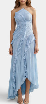 Robe longue plissée Mahaute avec col halter, volants asymétriques et design élégant, portée sur un fond neutre.