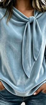 Blouse en velours Mahaute Solévia avec col lavallière et manches longues, élégante et douce, portée sur un fond neutre.