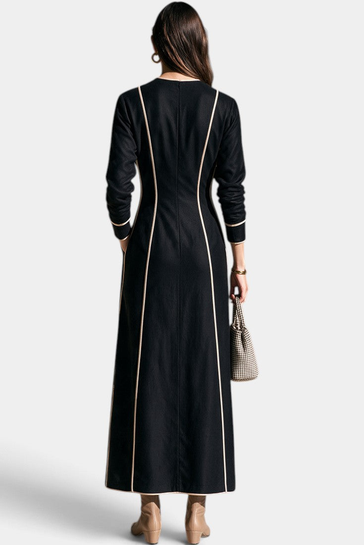 Robe longue Mahaute Katrien ajustée avec décolleté profond et finitions contrastées, tissu fluide et élégance sophistiquée.