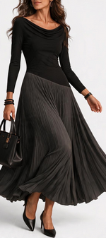 Mahaute Adelajda long black dress with draped neckline, long sleeves, and an asymmetrical pleated skirt.