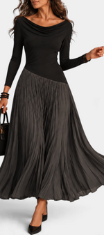 Mahaute Adelajda long black dress with a draped neckline, long sleeves, and an asymmetrical pleated skirt.