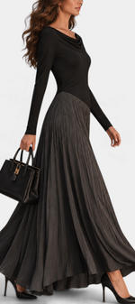 Mahaute Adelajda long black dress with draped neckline, long sleeves, and an asymmetrical pleated skirt in motion.