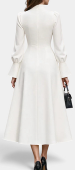 Back view of Mahaute Albena midi dress in white with puffed sleeves, flared skirt, and high gathered neckline.