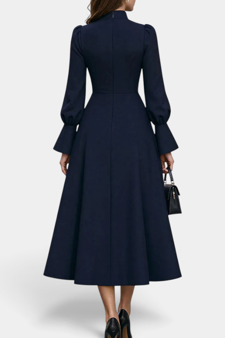 Mahaute Albena navy midi dress with a high ruffled collar, cinched waist, and voluminous puff sleeves, back view.