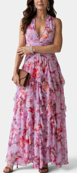 Robe longue fleurie Mahaute Amaya avec dos nu, volants cascade et motif floral, portée en mode élégante et féminine.
