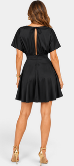 Mahaute Ambre black satin short dress with open back, tie detail, and flared skirt, back view.