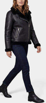Veste courte Mahaute Anseline en faux cuir noir avec col fourré et fermeture zippée, style aviateur.