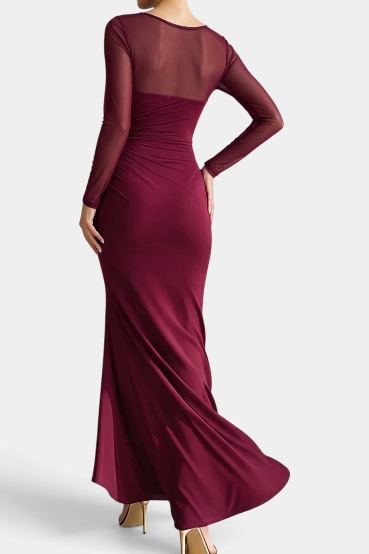 Robe longue Mahaute Apolonia en bordeaux, drapée avec décolleté cœur, manches transparentes et fente élégante.