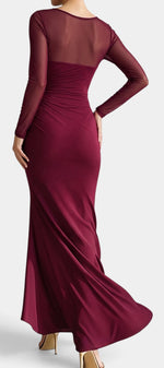 Robe longue Mahaute Apolonia en bordeaux, drapée avec décolleté cœur, manches transparentes et fente élégante.