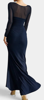 Robe longue Mahaute Apolonia en tissu drapé bleu marine, décolleté cœur, manches transparentes et fente élégante.