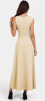 Robe longue beige Mahaute Eudocia avec col bénitier, taille ceinturée et style drapé, sans manches, élégante et fluide.