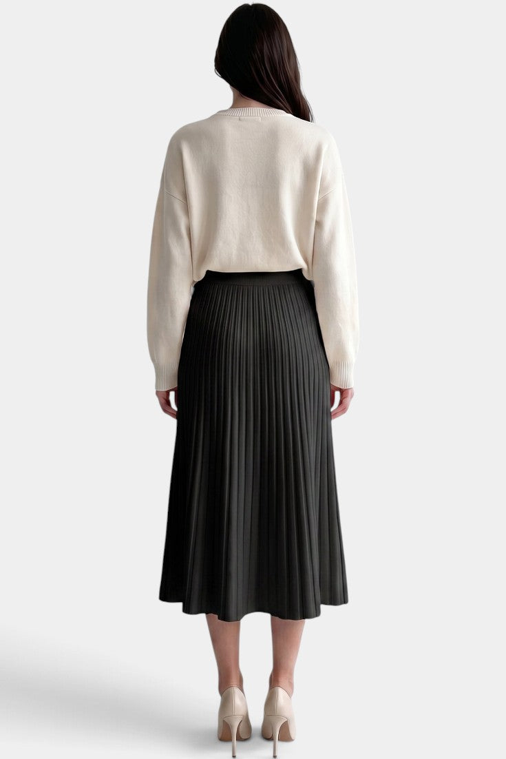 Jupe plissée longue noire Mahaute Belisaria, taille haute, coupe évasée, élégante et fluide, portée avec un haut blanc.
