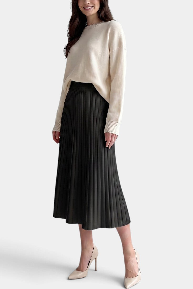 Jupe plissée longue noire Mahaute Belisaria, taille haute et coupe évasée, portée avec un haut blanc.