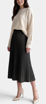Jupe plissée longue noire Mahaute Belisaria, taille haute et coupe évasée, portée avec un haut blanc.