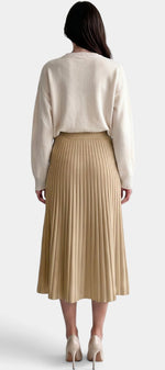 Jupe plissée longue beige à taille haute et coupe évasée de la marque Mahaute, portée avec un haut blanc.