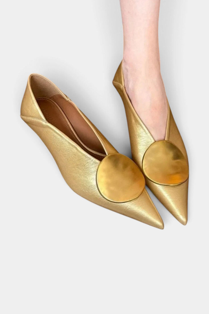 Mahaute Billini gold pointed-toe pumps with a low heel and large circular metallic ornament on the front