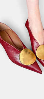 Mahaute Billini red pointed-toe kitten heel pumps featuring a large gold metallic circular ornament on the front