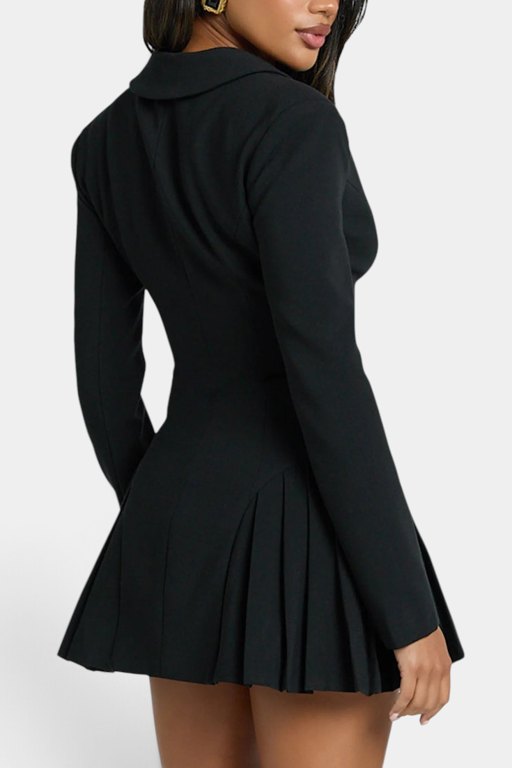 Model wearing a Mahaute black blazer dress with a cinched waist and pleated skirt, back view