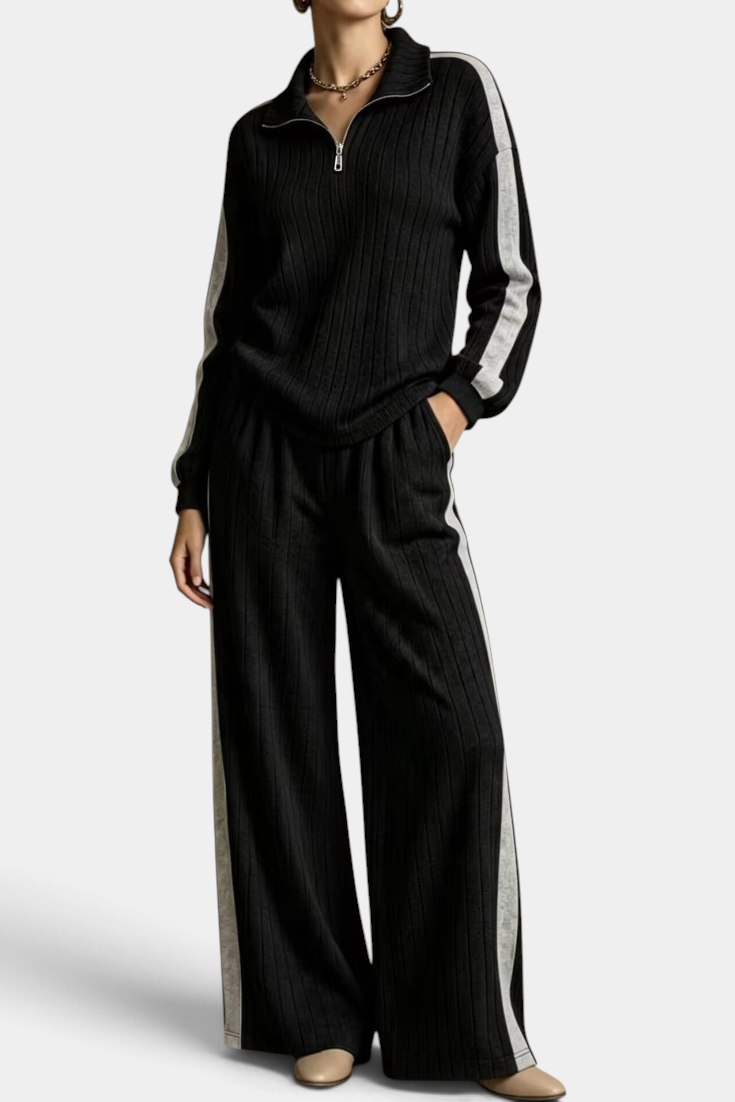 Mahaute black ribbed knit lounge set with zip-up sweater and wide-leg trousers featuring contrasting side stripes.