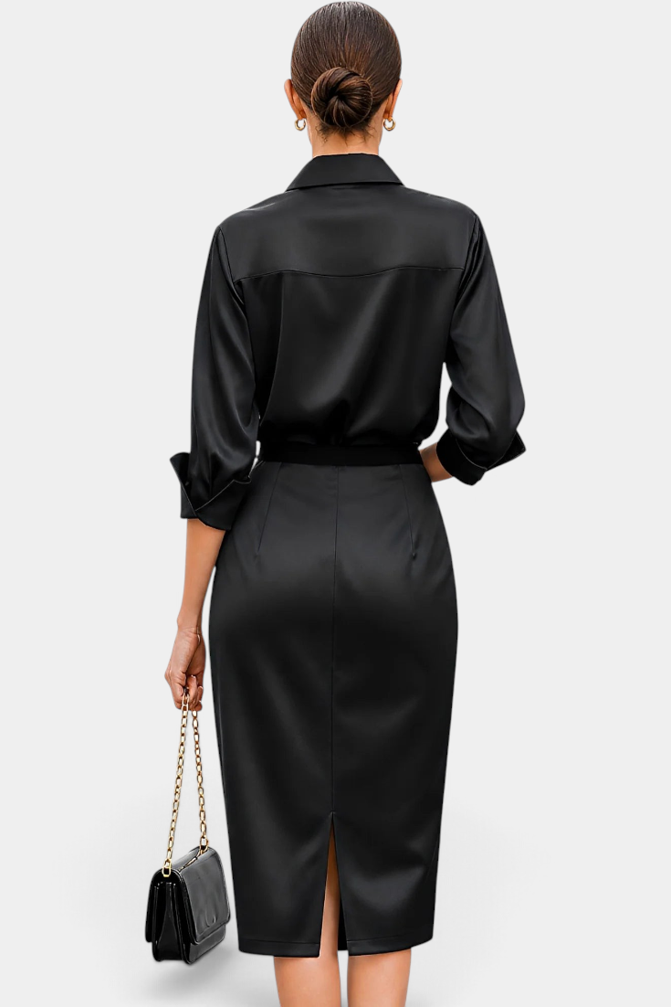 Back view of a Mahaute black satin midi shirt dress with long sleeves, a belted waist, and a back slit.