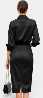 Back view of a Mahaute black satin midi shirt dress with long sleeves, a belted waist, and a back slit.