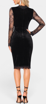 Back view of Mahaute Chantaline black velvet midi dress with sheer floral lace sleeves and hem, worn with heels.