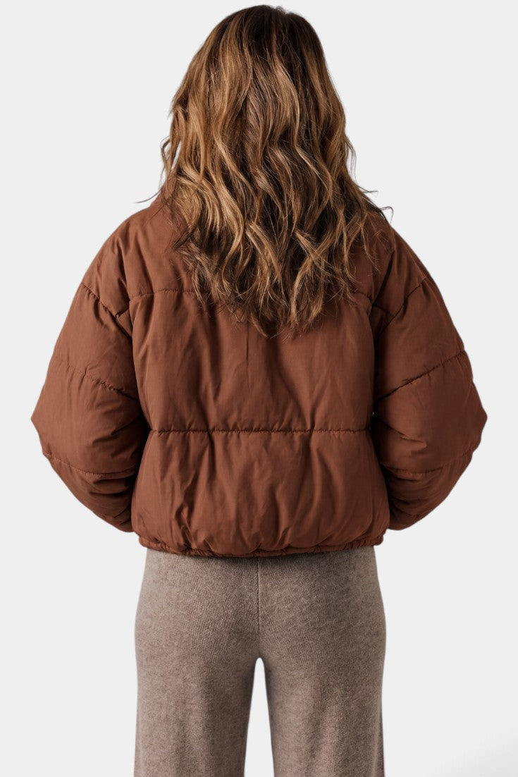 Doudoune courte matelassée Mahaute marron avec col montant et cordon de serrage, adaptée pour le froid.